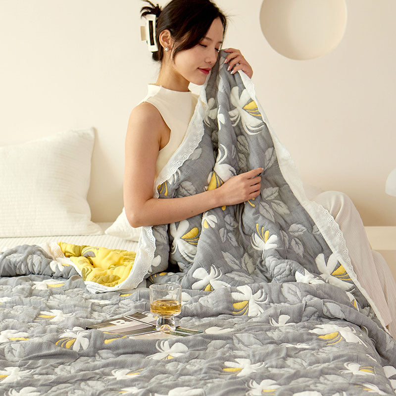 Woman relaxing with a Bamboo Fiber Blanket Summer Blanket featuring a floral design, enjoying soft cooling comfort.